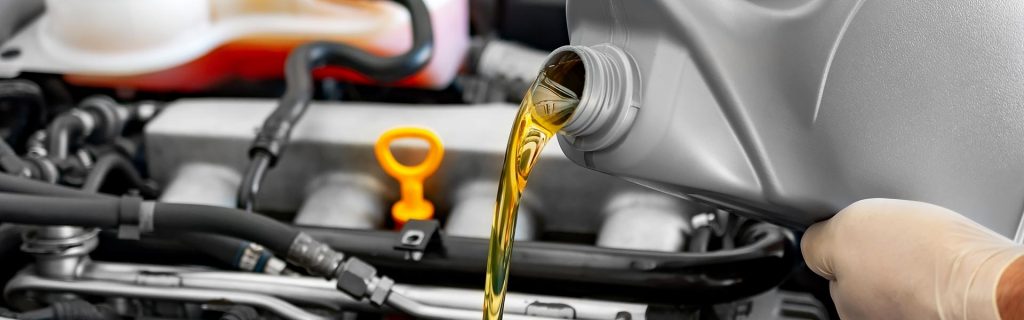 Motor oil being poured into a car engine.