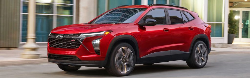 Red Chevrolet SUV driving down a city street